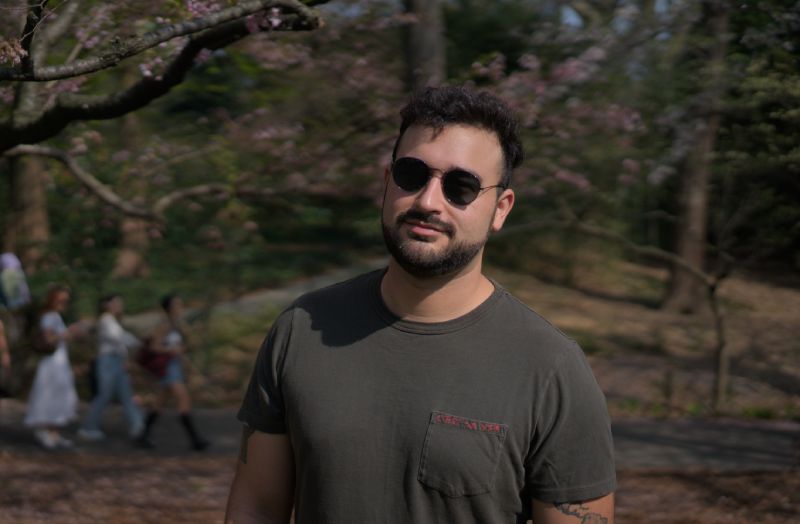 Lucas standing in cherry blossoms.